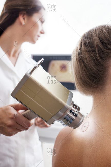 Young woman in skin clinic having mole scanned