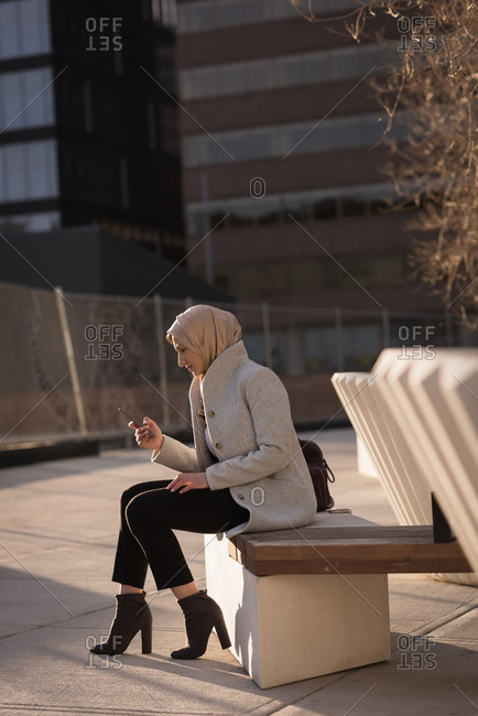 Woman in hijab using mobile phone on a sunny day