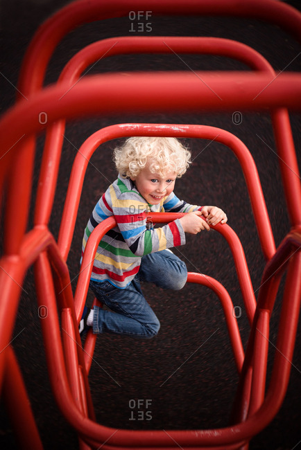 Boy climbs on playground equipment