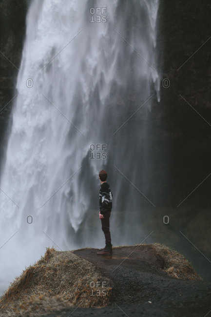 Boy looking at waterfall, Iceland