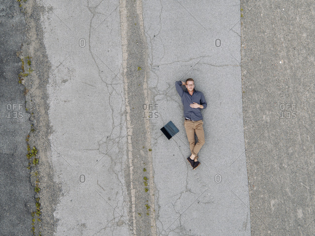 Young businessman with laptop relaxing in solitude- quadcopter view