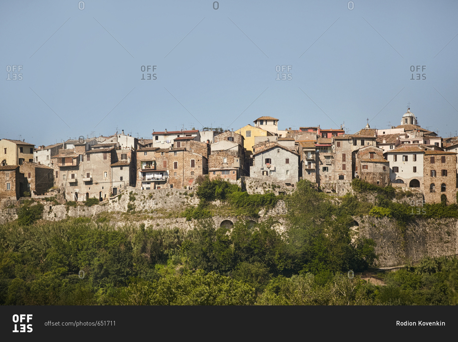 View of densely packed houses of hilltop town in Italy stock photo - OFFSET