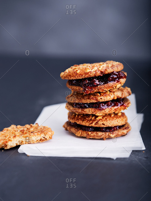 Half eaten cookie next to a stack of irresistible cookies with jam