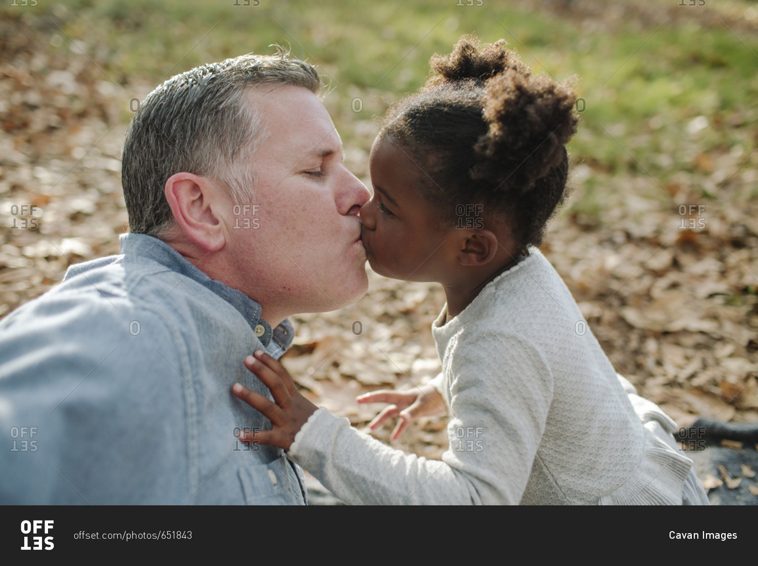 Close-up of daughter kissing father. 