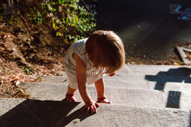 Toddler climbing up steps outside