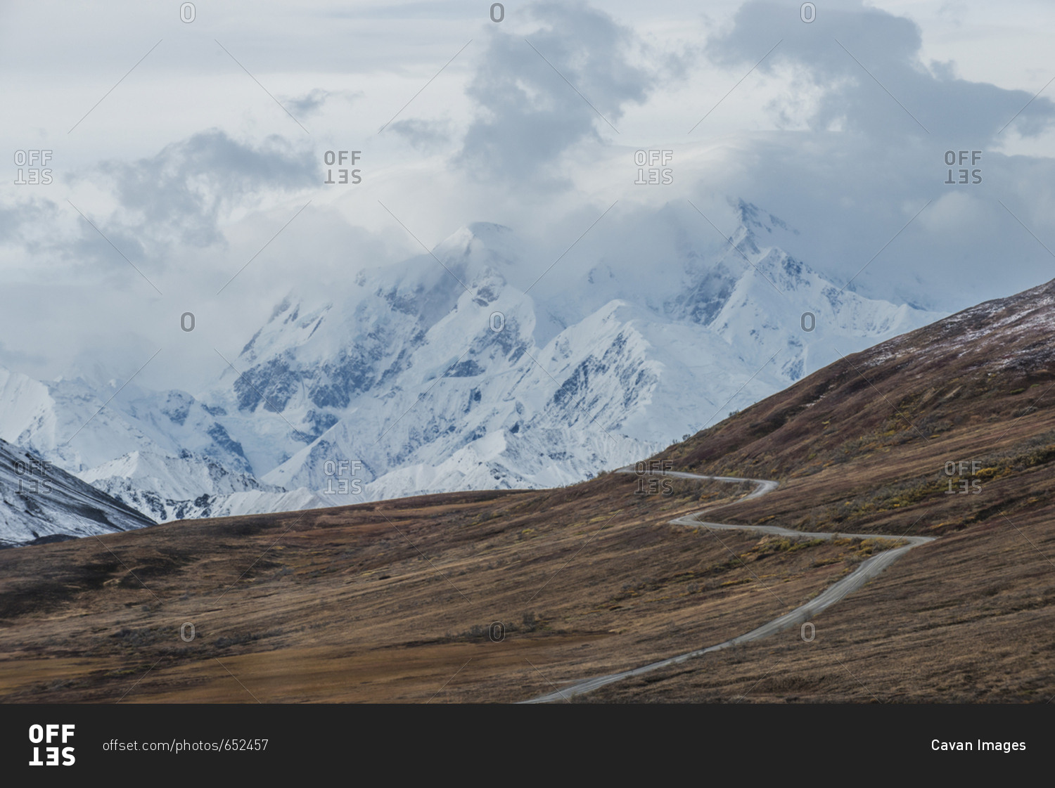 Scenic view of road amidst field against snowcapped mountains at Denali National Park and Preserve during foggy weather