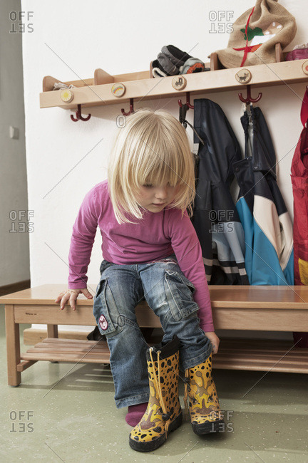 Girl Pulling On Boots, Kottgeisering, Bavaria, Germany, Europe