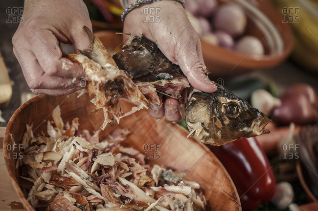 Preparing smoked pike, holding the animal head