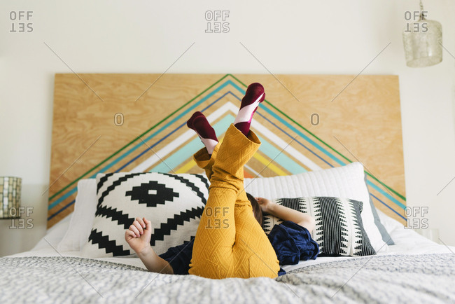 Bare feet of a little girl hiding in a box stock photo - OFFSET