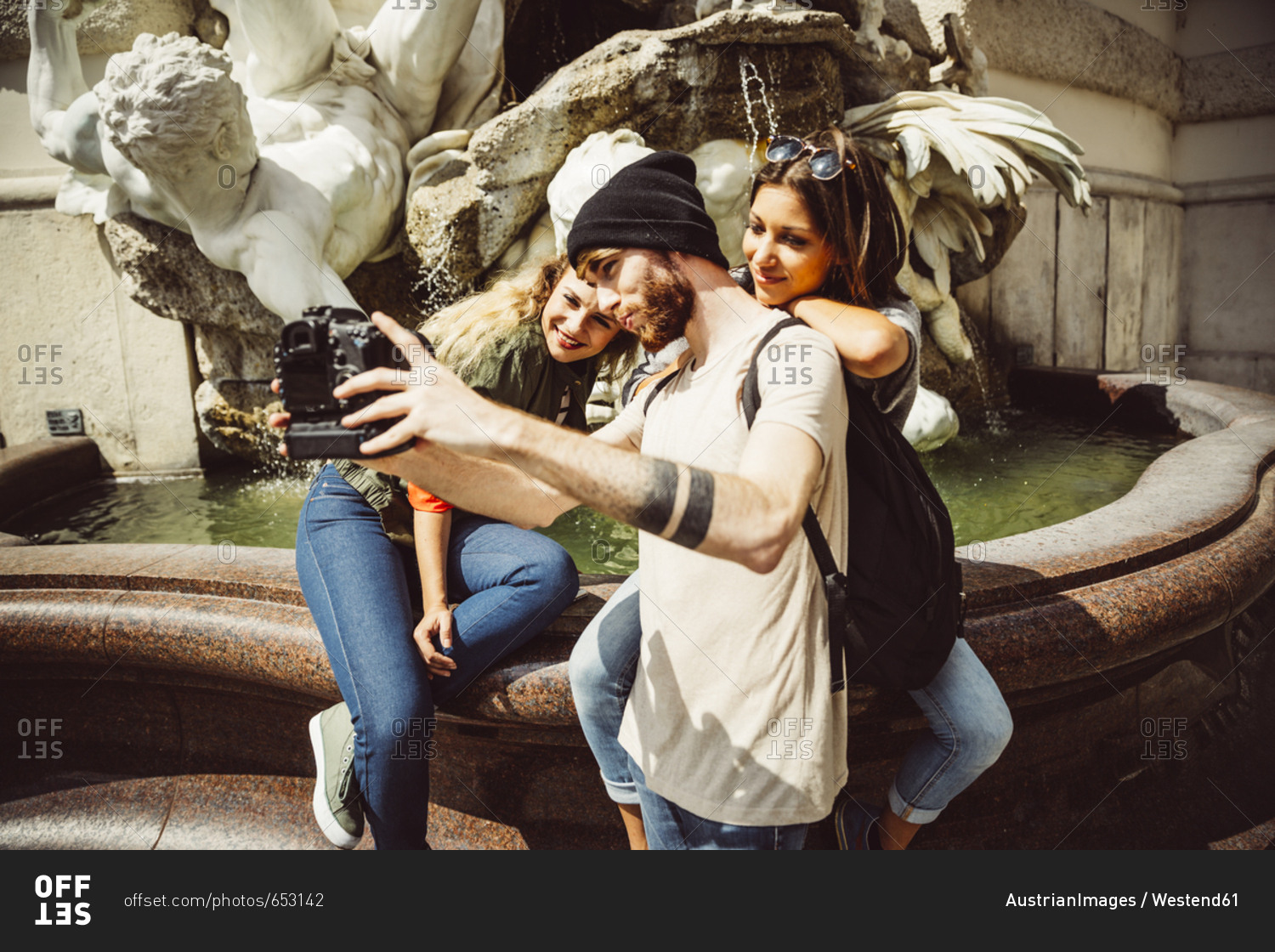 Austria- Vienna- group of three friends taking a selfie in front of fountain at Hofburg Palace