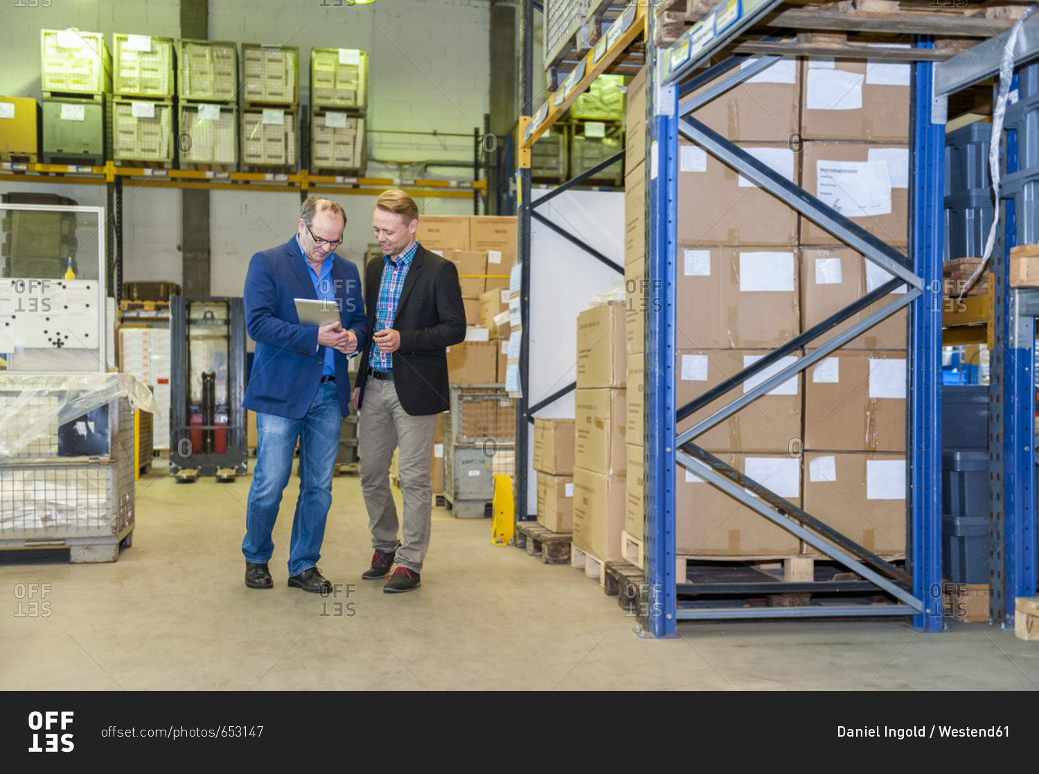 Two managers discussing packaging and shipment in storage hall
