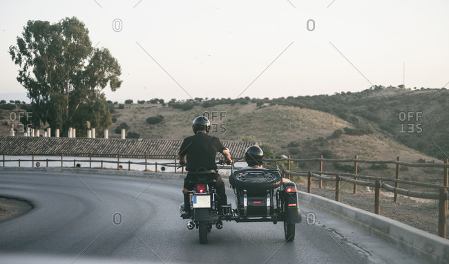Spain- mature couple riding on motorcycle with a sidecar