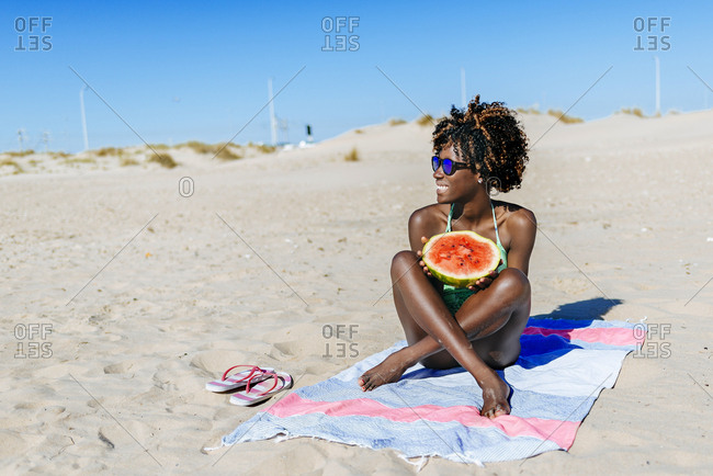 Happy young woman with watermelon on the beach