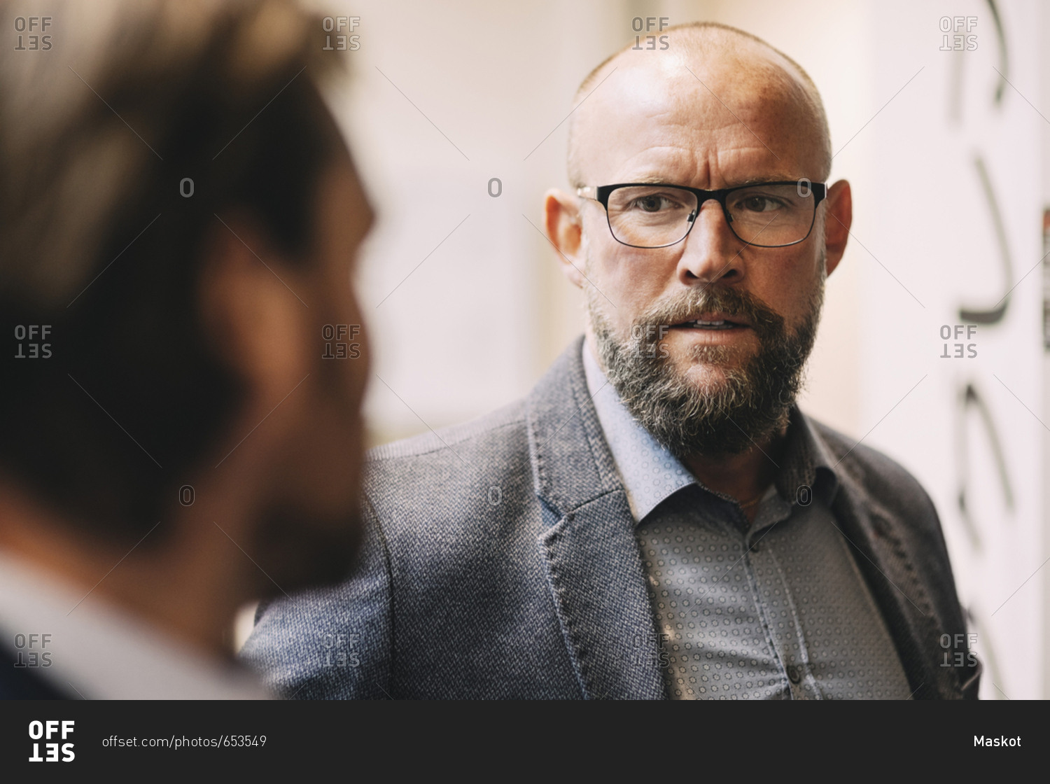 Close-up of businessman discussing with colleague at office