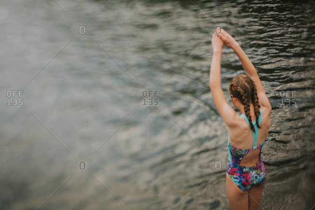 Freelensed and soft focus image of a girl jumping in a river