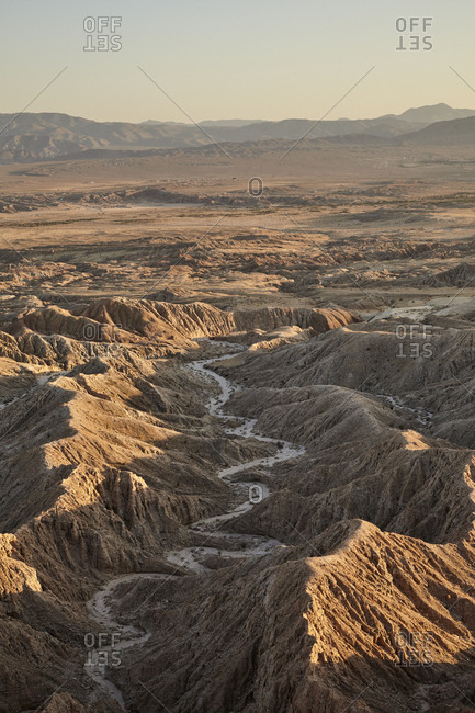 Scenic view of river between barren mountain ranges