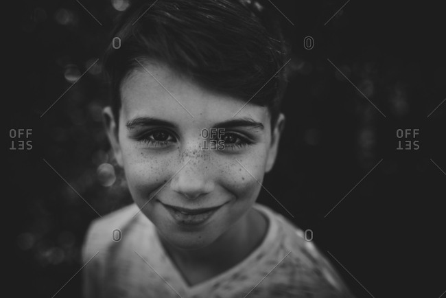 Portrait of a smiling boy with freckles in black and white