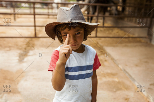 Clever farm boy gesturing with playful grin
