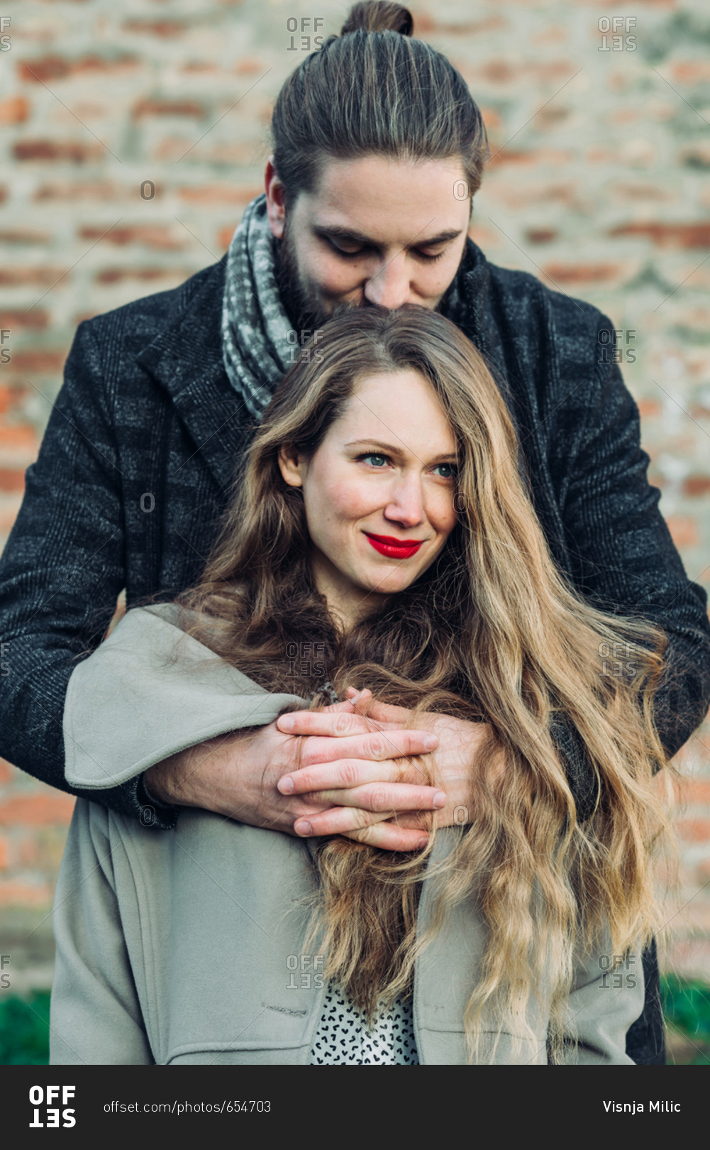 Portrait of beautiful young couple hugging and smiling looking in love