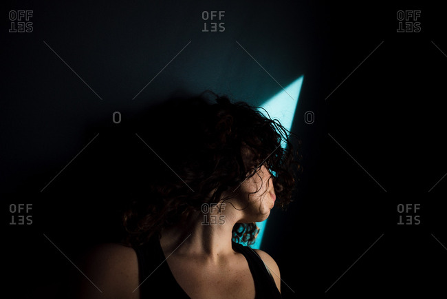 Woman in dark room with head tilted away