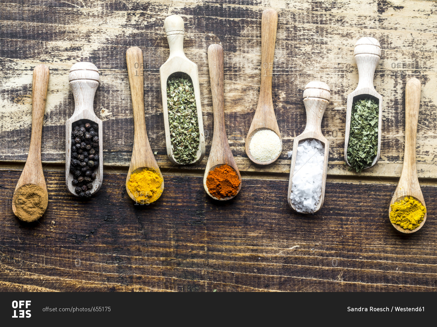Spices- curry- chilli- cinnamon- curcuma- garlic- parsley- oregano- salt and pepper on wooden spoons