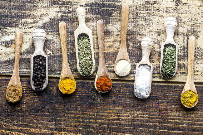 Spices- curry- chilli- cinnamon- curcuma- garlic- parsley- oregano- salt and pepper on wooden spoons