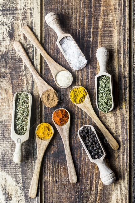 Spices- curry- chilli- cinnamon- curcuma- garlic- parsley- oregano- salt and pepper on wooden spoons