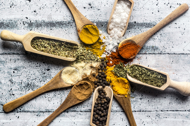 Spices- curry- chilli- cinnamon- curcuma- garlic- parsley- oregano- salt and pepper on wooden spoons