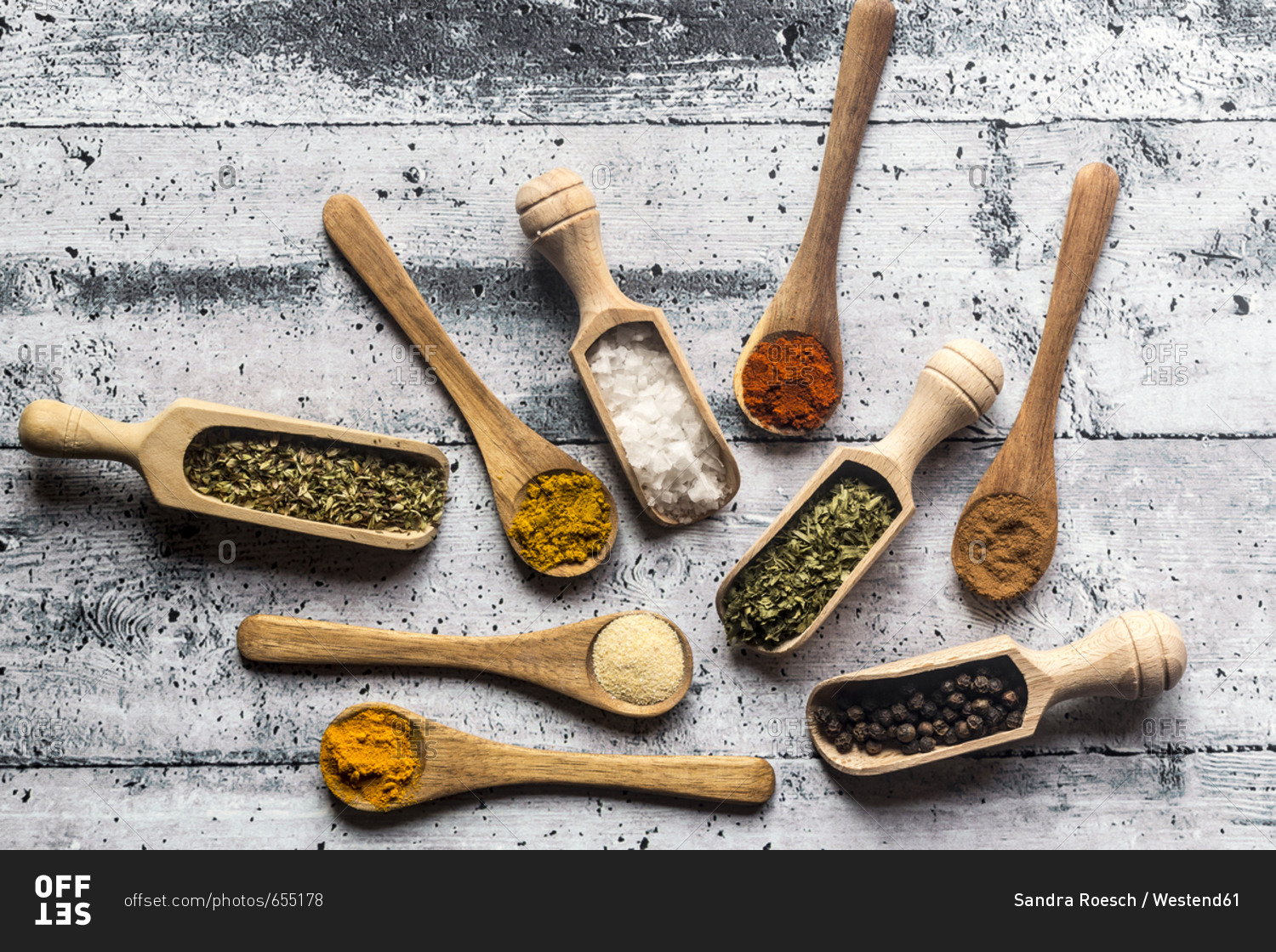 Spices- curry- chilli- cinnamon- curcuma- garlic- parsley- oregano- salt and pepper on wooden spoons
