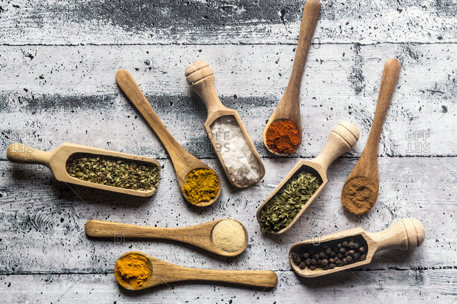 Spices- curry- chilli- cinnamon- curcuma- garlic- parsley- oregano- salt and pepper on wooden spoons