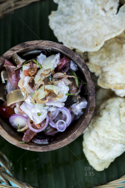 Overhead view of ceviche accompanied with prawn crackers
