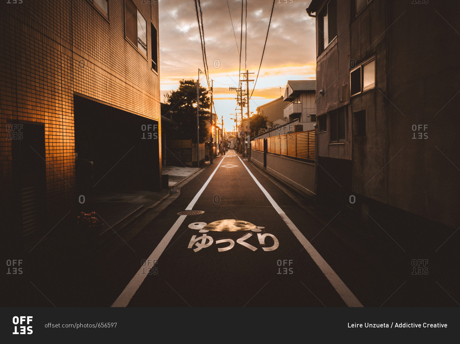 Perspective view to asphalt walkway in the town in sunset lights