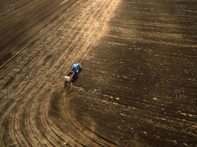 Aerial view of farmer plowing in a farm in the countryside.
