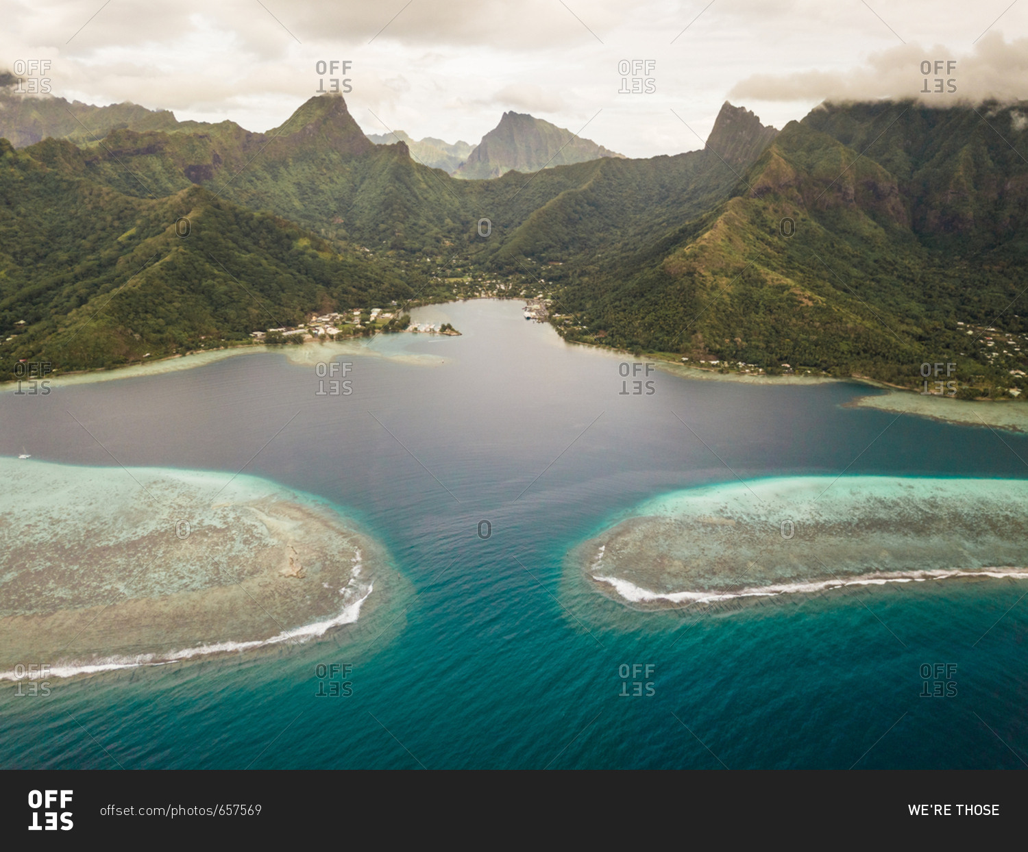 Aerial view of Moorea island and its shallow lagoon surrounded by the island's vertical mountains.