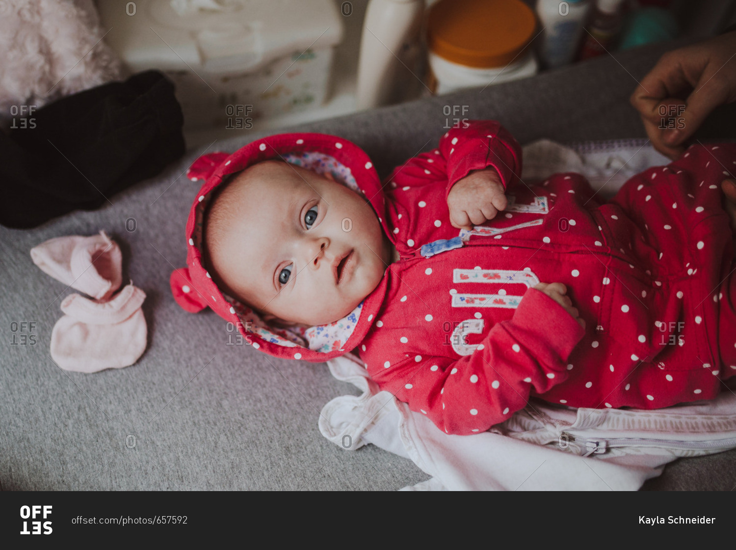 Little baby girl lying on changing table stock photo OFFSET