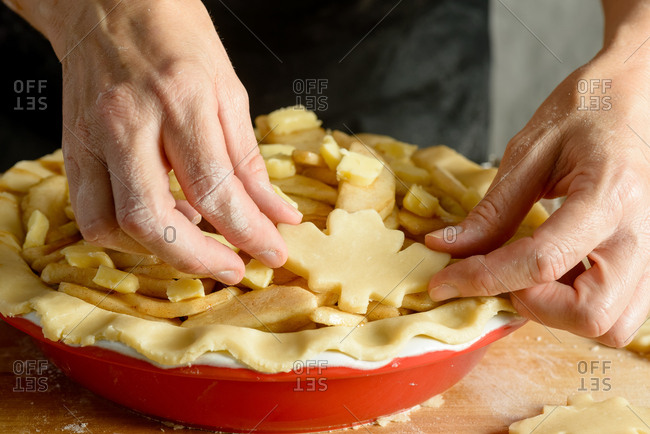 Arranging maple leaf shapes for apple pie crust