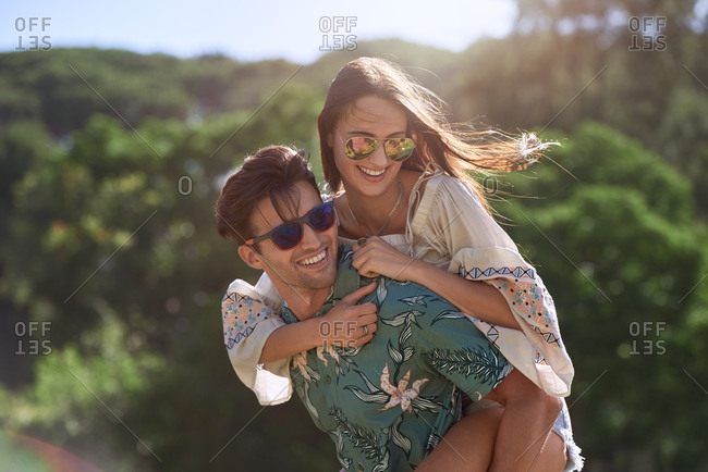 Sweet young couple in love relationship having fun smiling and laughing outdoors piggyback