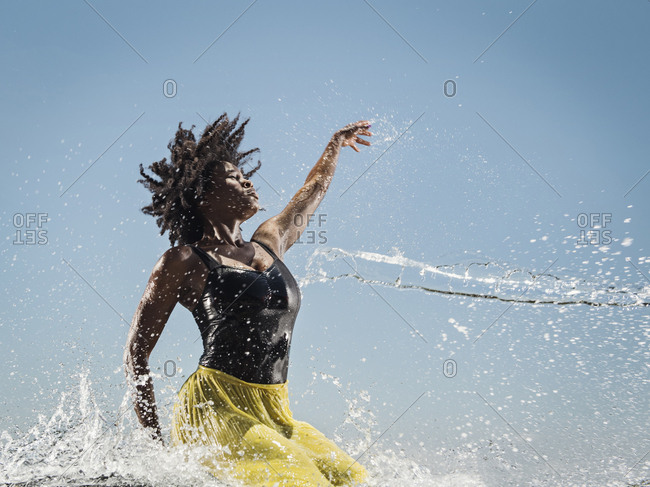 Water spraying on black woman dancing stock photo - OFFSET