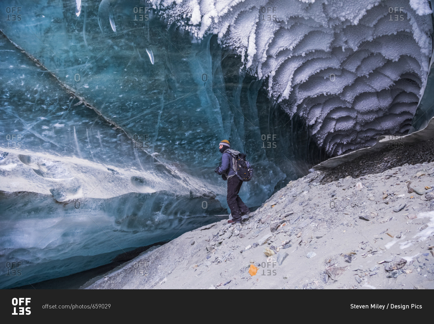 A Man Explores A Tunnel Beneath The Ice Of Canwell Glacier In The ...