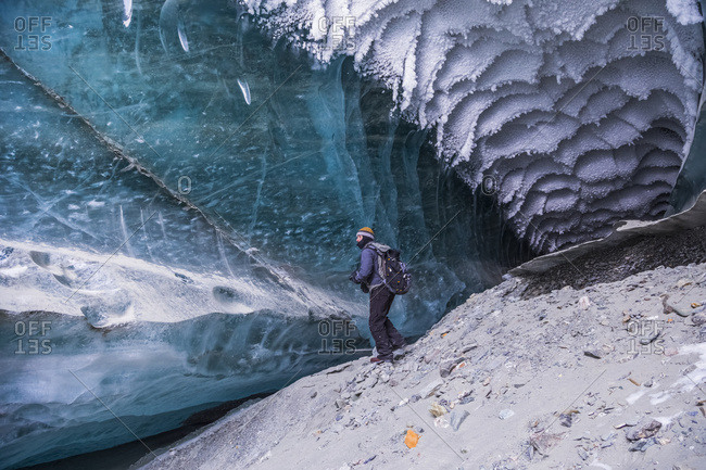 A Man Explores A Tunnel Beneath The Ice Of Canwell Glacier In The Alaska Range In Winter; Alaska, United States Of America