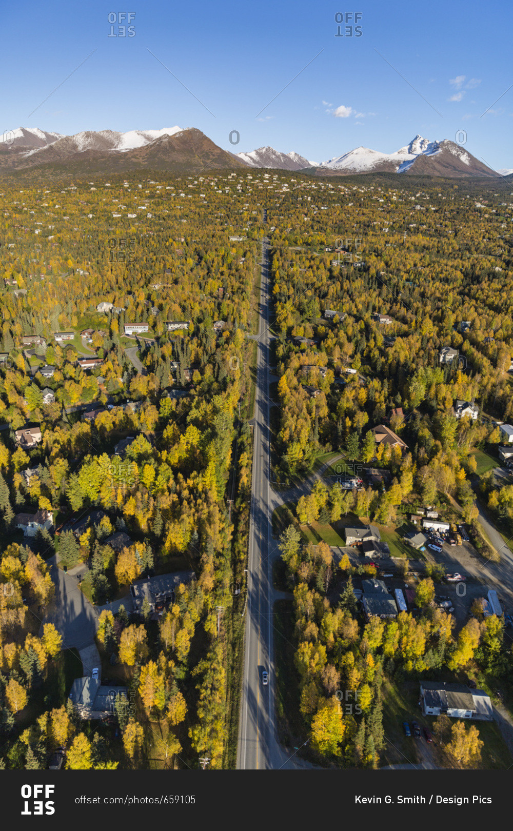 Aerial View Of The Hillside Neighborhood Homes In Anchorage, Snow Covering The Peaks Of The Chugach Mountains In The Background, Autumn Coloured Trees Filling The City, South-Central Alaska; Alaska, United States Of America