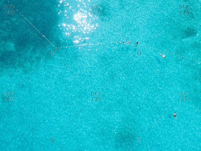 Aerial view of tourists swimming in beautiful clear sea water
