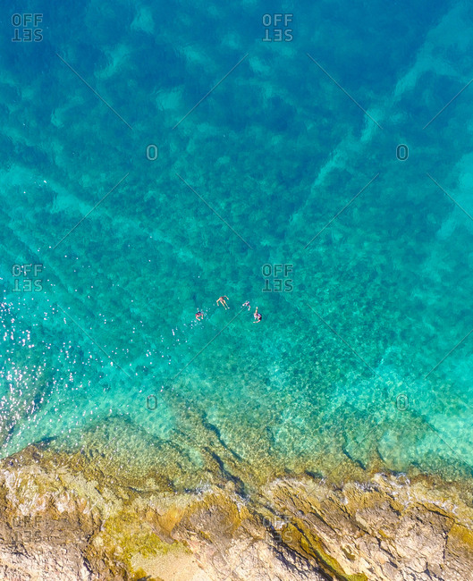 Aerial view of tourists swimming in beautiful clear sea water