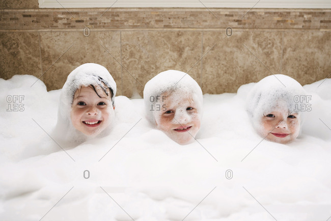 High angle view of three kids in a bubble bath stock photo 