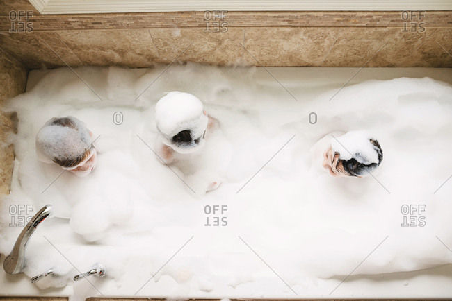 Children play in bubble bath stock photo - OFFSET