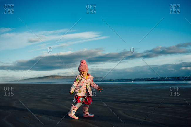 Toddler girl on a beach in the fall