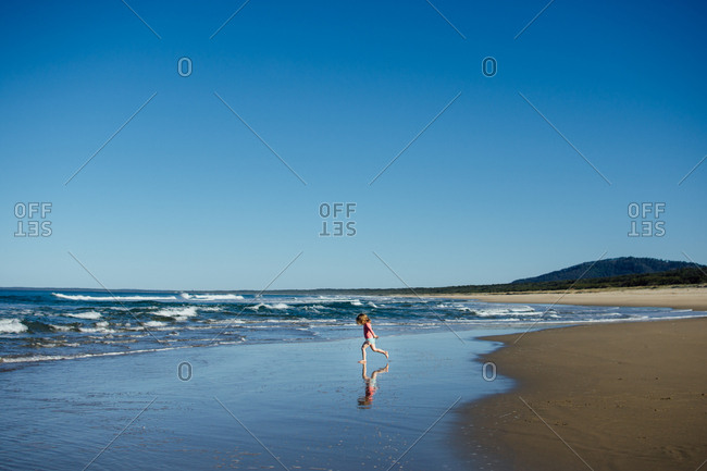 Girl running in the tide on a beach