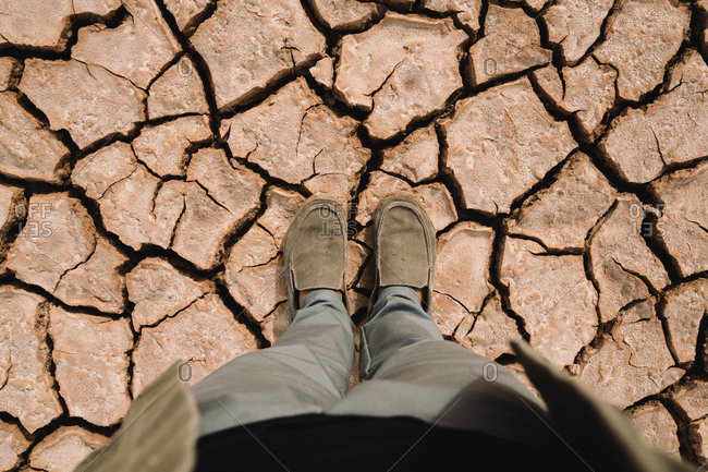Low section of man standing at barren landscape