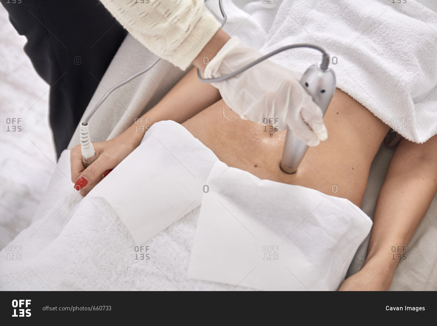 High angle view of female doctor using medical equipment while treating patient at medical clinic