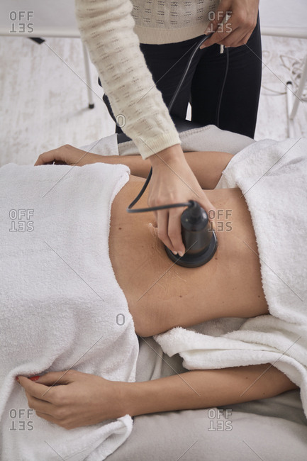 Midsection of female doctor using medical equipment while treating patient at medical clinic